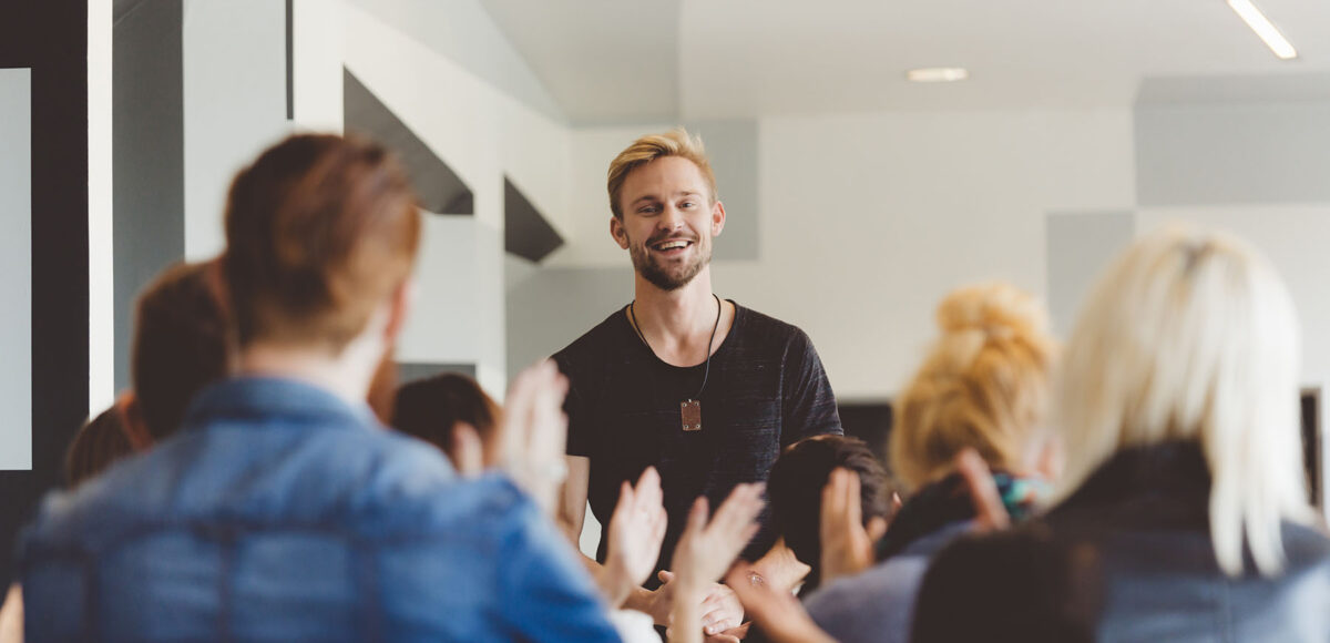 group celebrating young man for personal development
