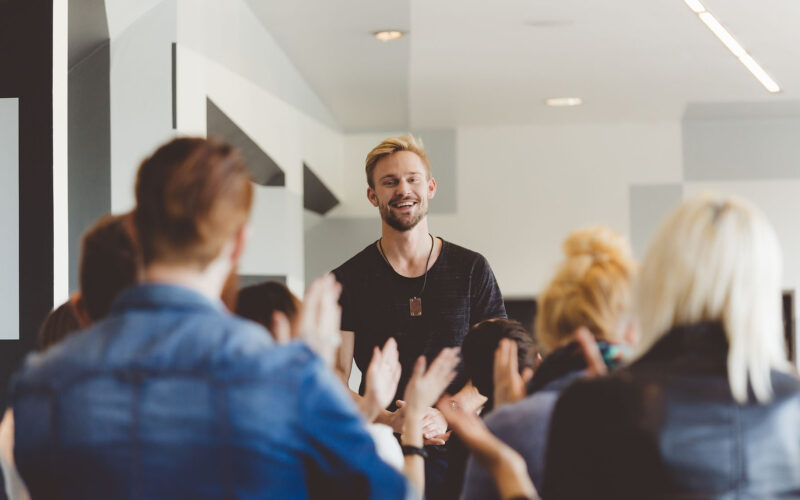 group celebrating young man for personal development