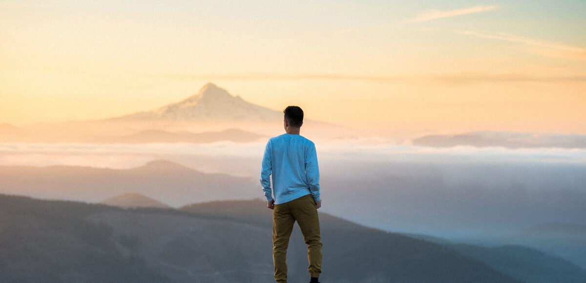 man asking himself self improvement questions on top of mountain